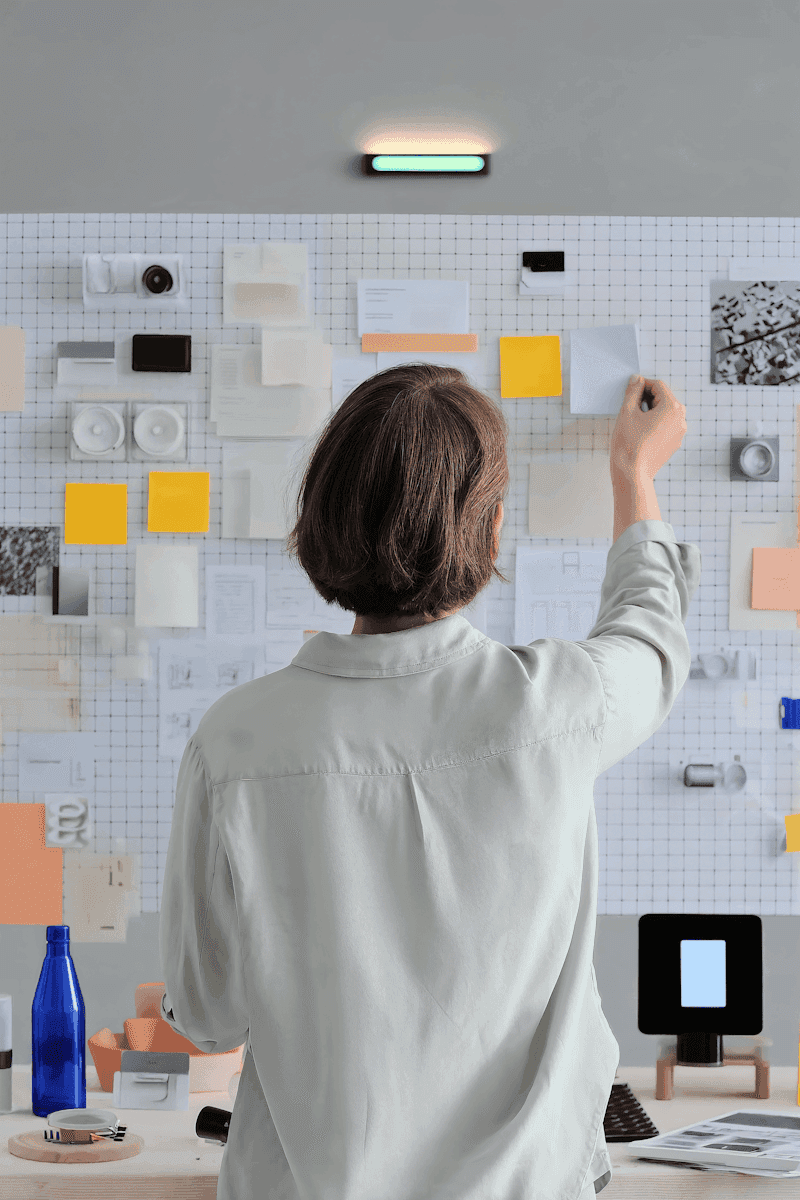 Overhead view of person working with design materials on a grid board